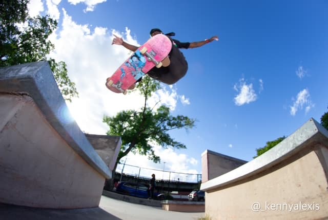 Leon Toppin mid-air during a grab trick at a concrete skatepark