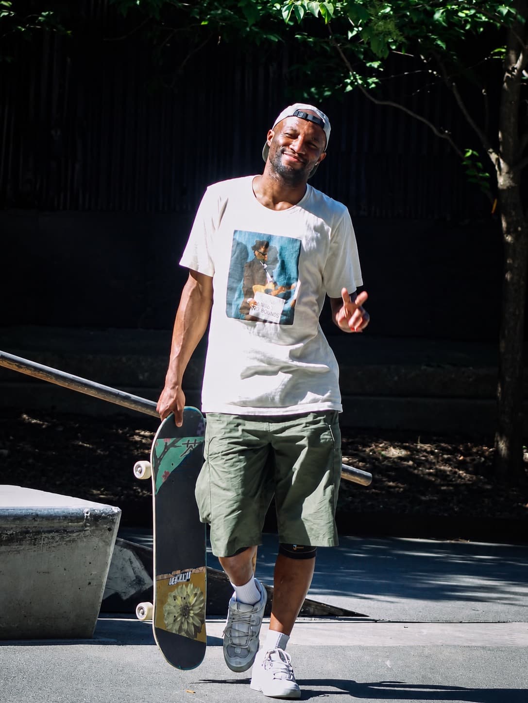 Leon Toppin standing at a skatepark, smiling and holding his skateboard