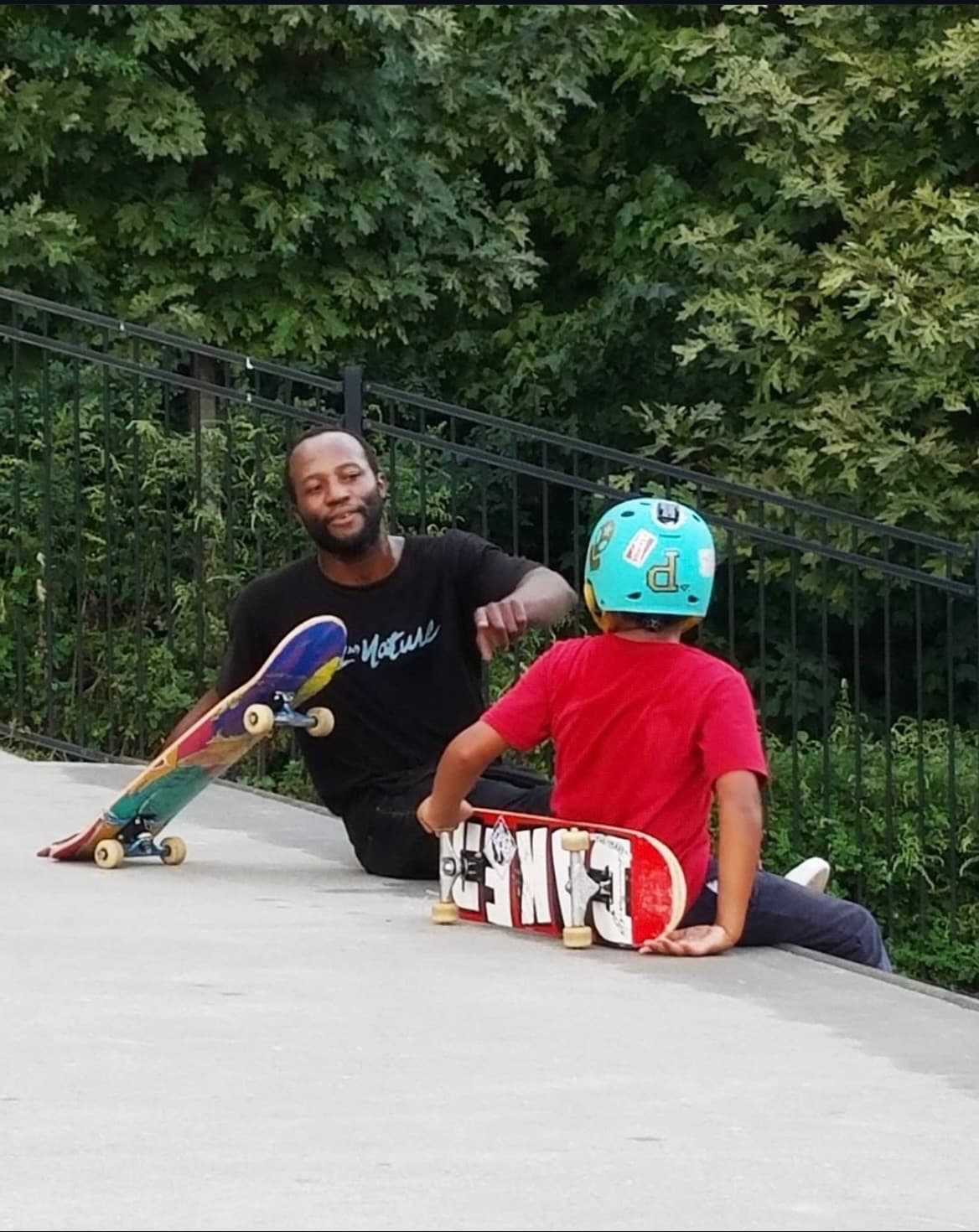 Leon Toppin teaching a young student to skateboard at a Westchester County skatepark